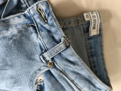 Jeans de mezclilla azul claro con diseño desgastado - miniatura 1