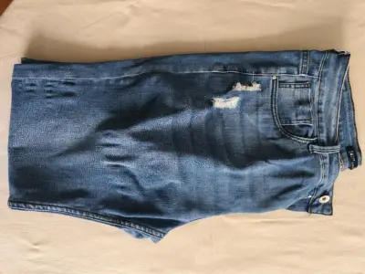 Jeans de mezclilla azul con diseño desgastado - miniatura 1