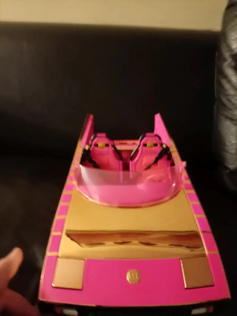 Auto de juguete, rosa y dorado a pilas con luces.