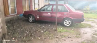 Auto Nissan sedán rojo en buen estado - miniatura 1