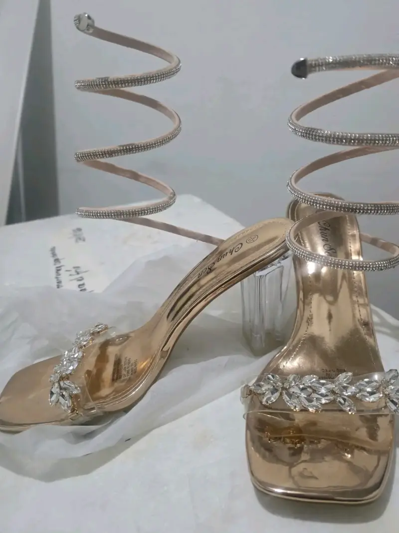 Sandalias doradas con tacón transparente y adornos - 1