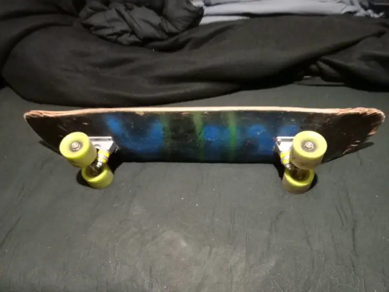Skateboard con ruedas verdes y diseño azul - 1