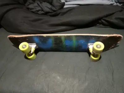 Skateboard con ruedas verdes y diseño azul - miniatura 1