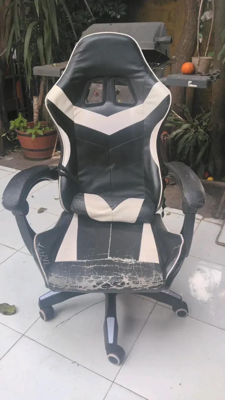 Silla gamer negra y blanca desgastada