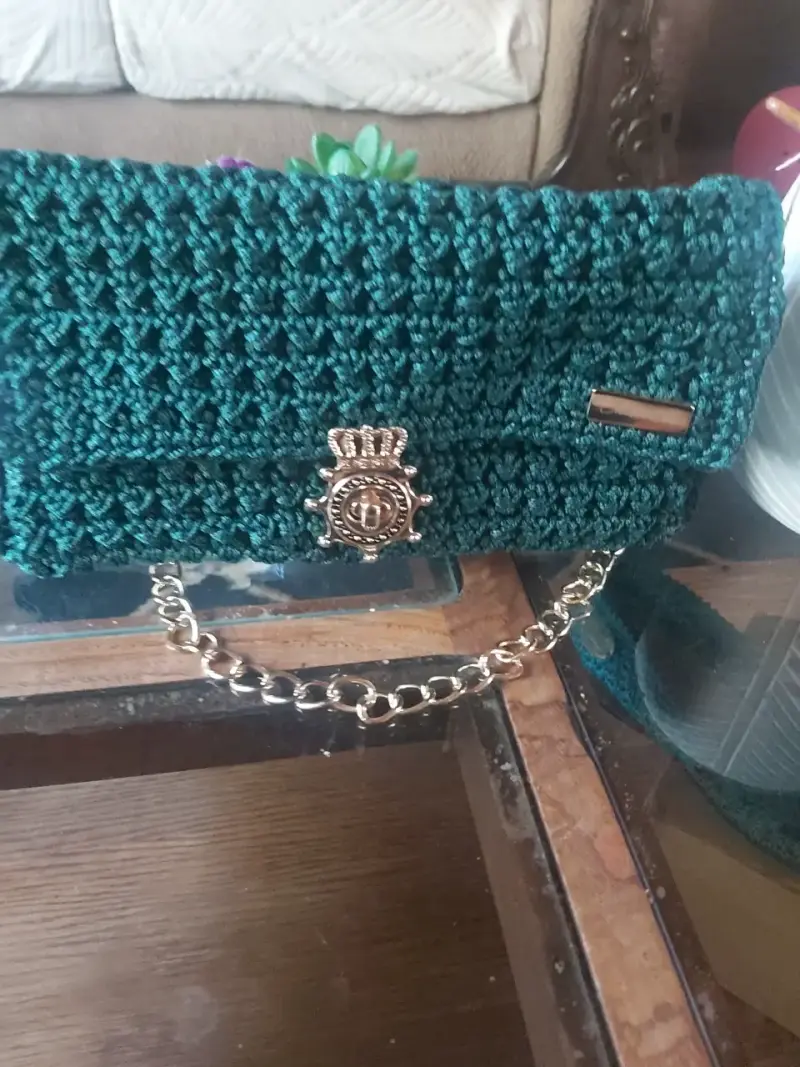 Cartera de mano tejida verde con cadena