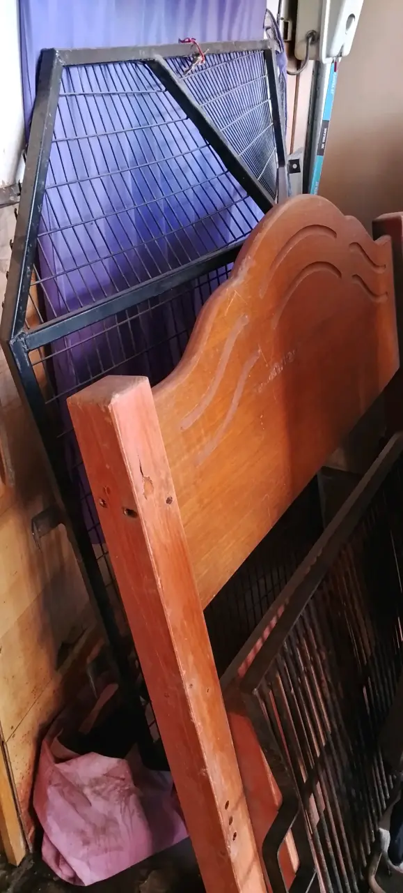 Estructura de cama de madera y una reja de fierro