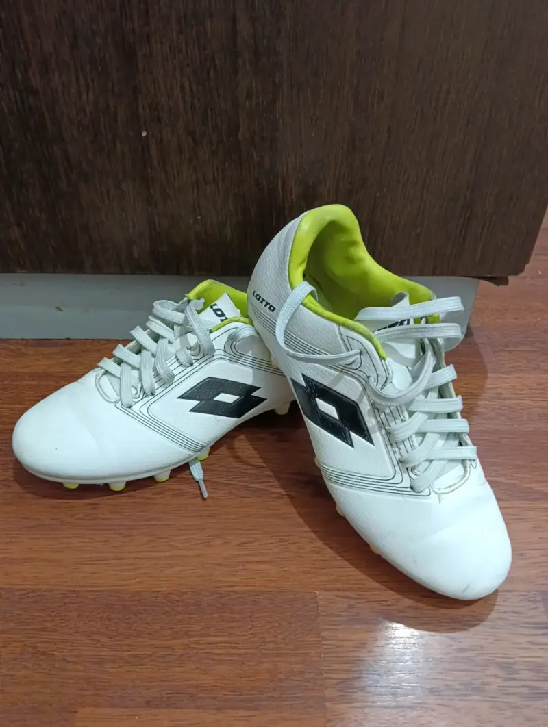 Botines de fútbol Lotto blancos con detalles negros