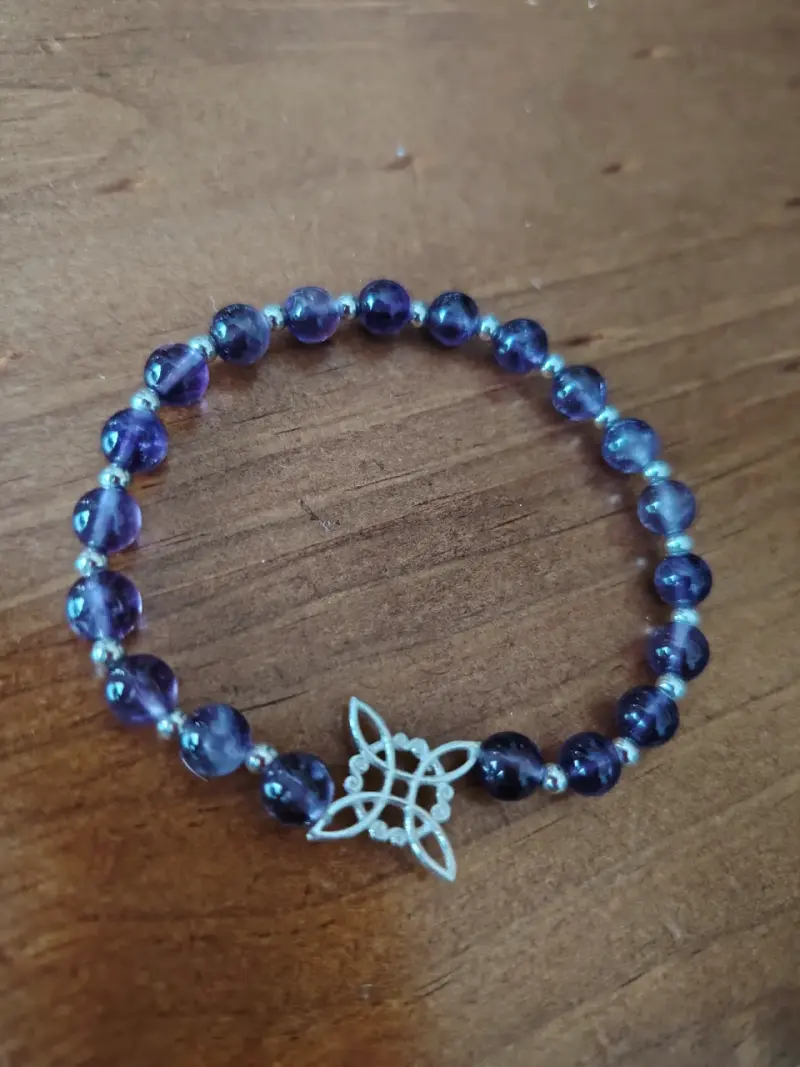 Pulsera de cuentas moradas con dije decorativo