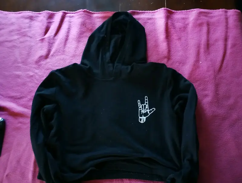 Polerón negro con capucha y diseño de mano