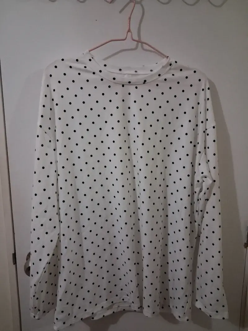 Camiseta blanca de lunares negros.