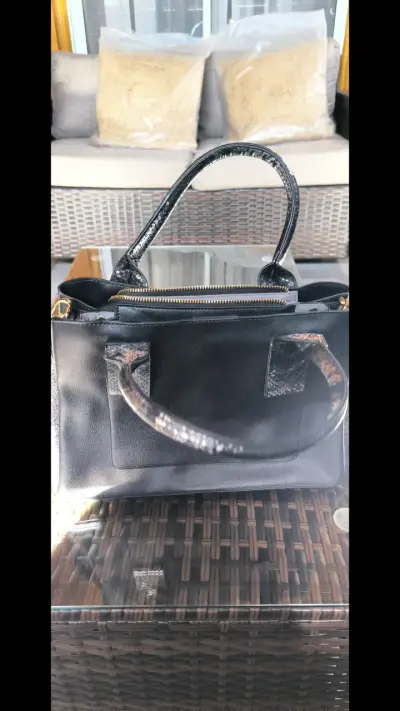 Bolso de mano negro elegante con detalles en serpiente - miniatura 1