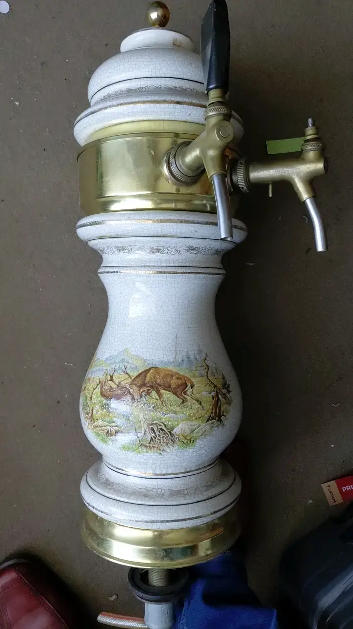 Antiguo dispensador de cerveza de cerámica y latón