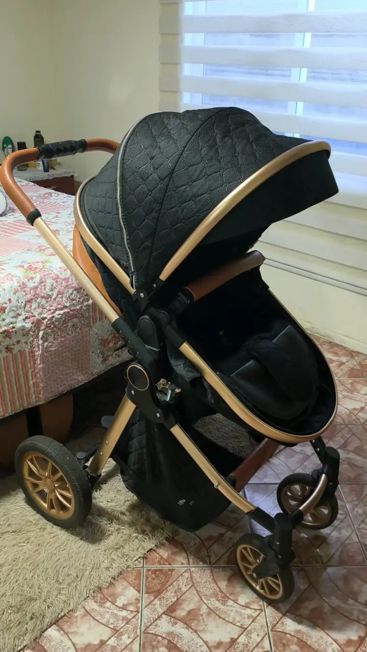 Coche de bebé negro con detalles dorados - 5