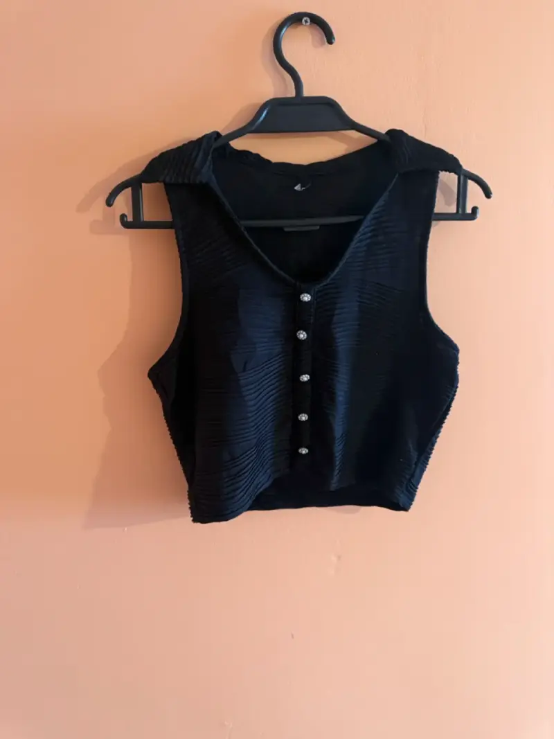 Top negro sin mangas con botones decorativos