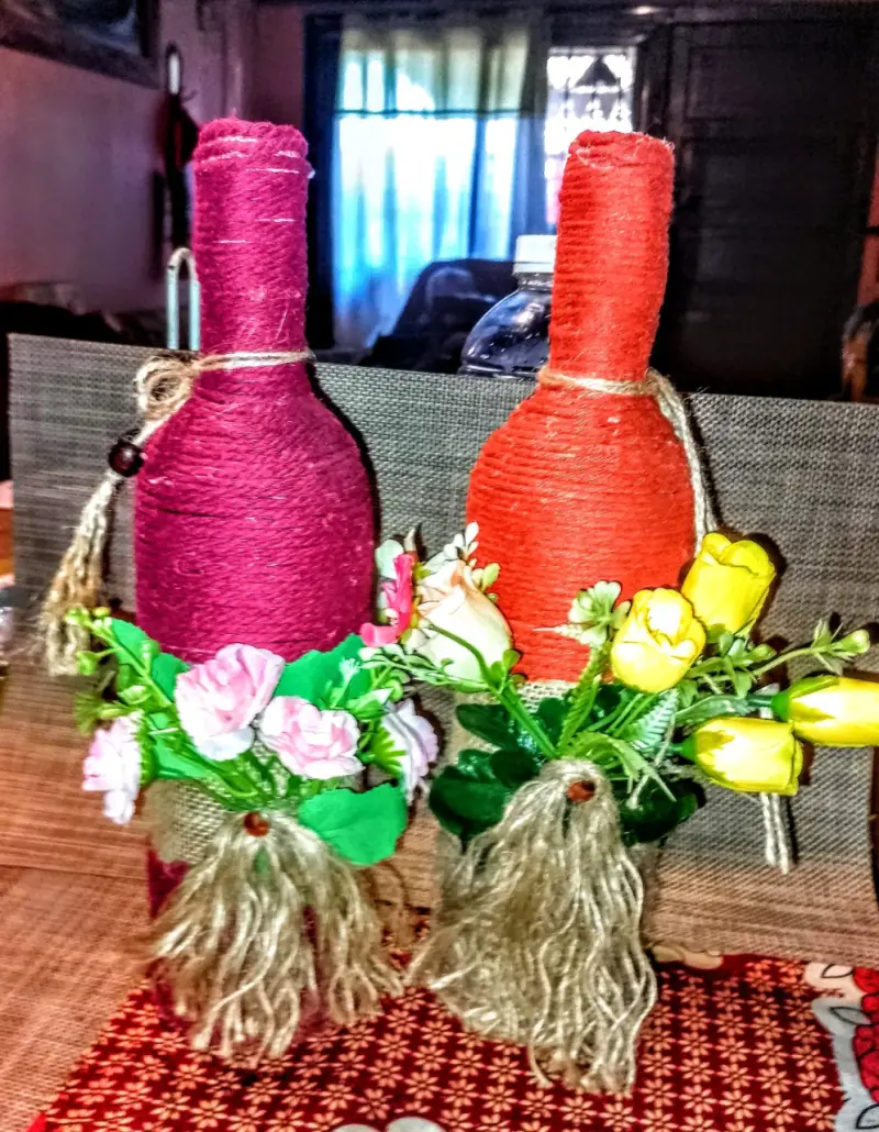 Botellas decorativas con hilo y flores artificiales