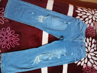 Jeans de mezclilla azul con diseño rasgado - miniatura 1