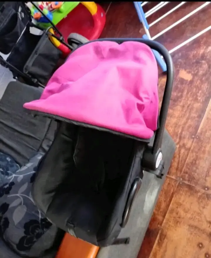 Coche de bebé con capota rosa y estructura negra - 2