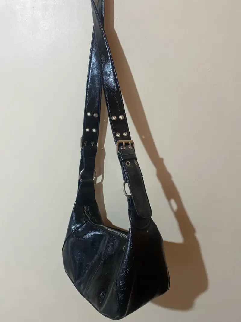 Cartera de cuero negra con detalles metálicos