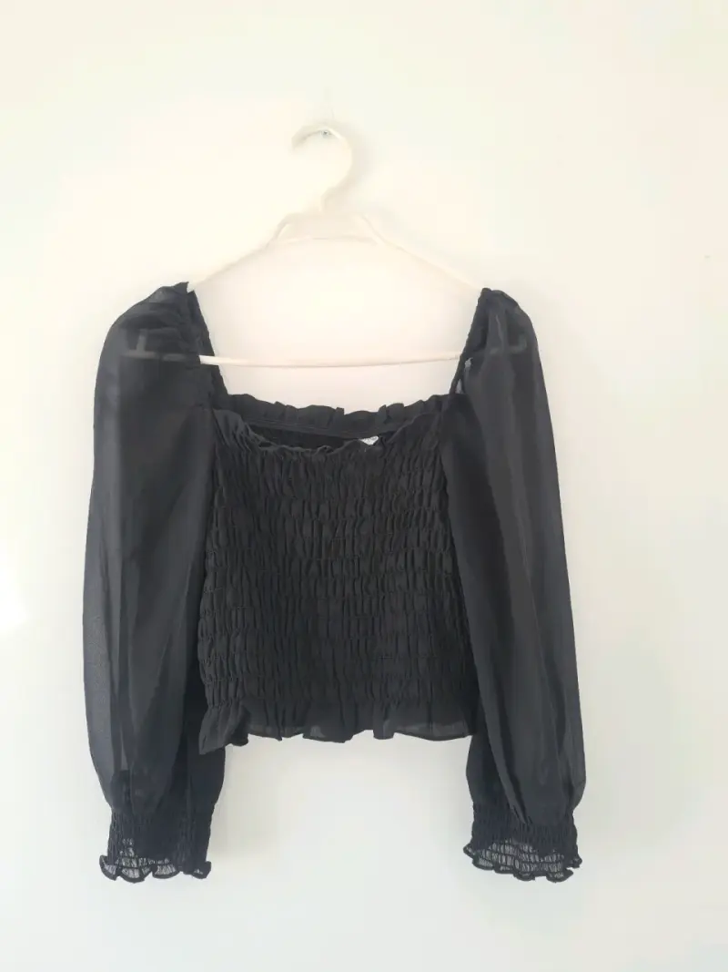 Blusa negra con mangas largas transparentes