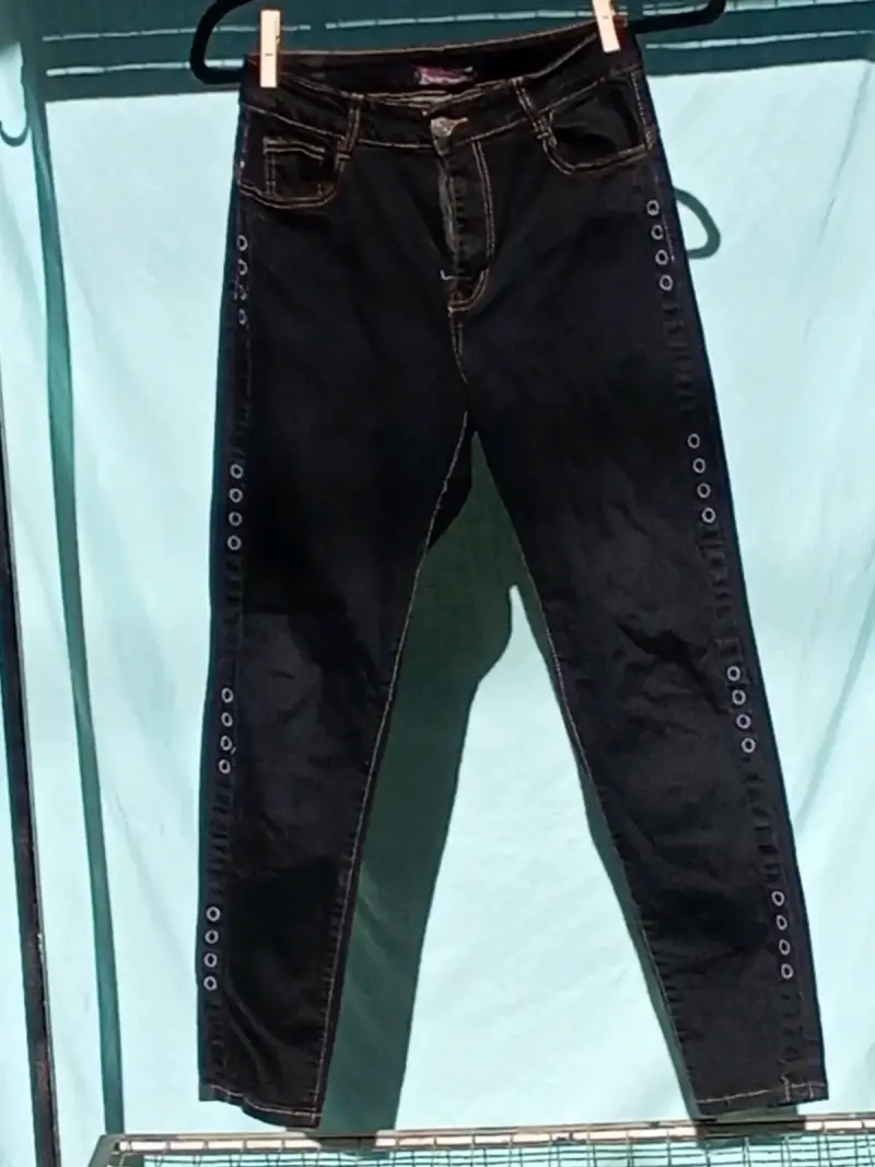 Jeans negros con ojales decorativos