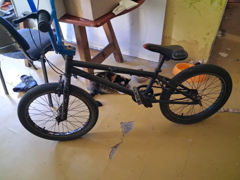 Bicicleta BMX negra con manubrio azul - 1