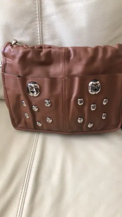 Cartera de cuero marrón con detalles metálicos - miniatura 1
