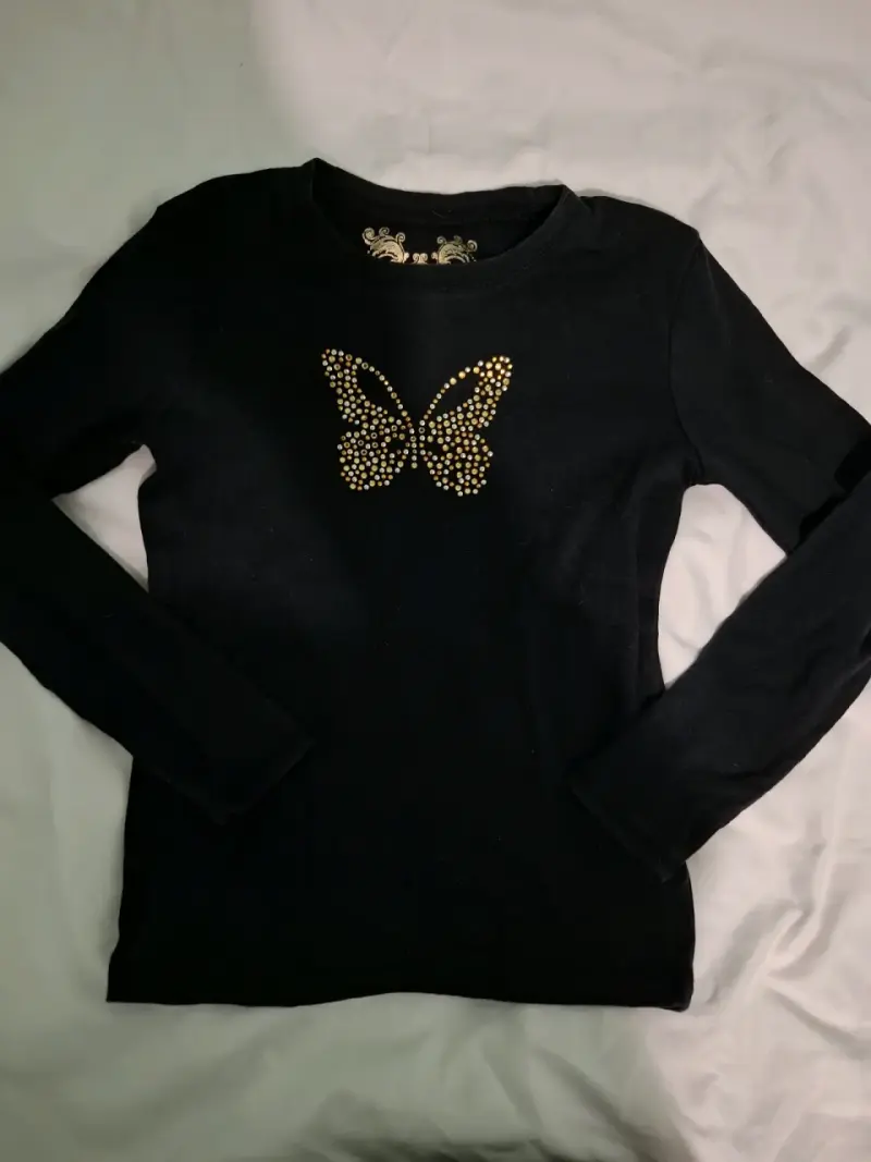 Polera negra con diseño de mariposa en el pecho - 1