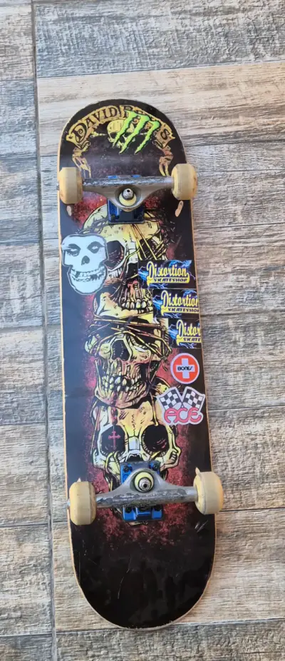 Skateboard con diseño de calaveras y stickers - miniatura 1