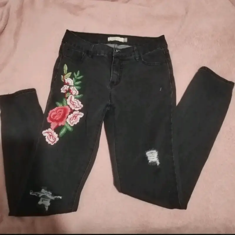Jeans negros con bordado floral para mujer