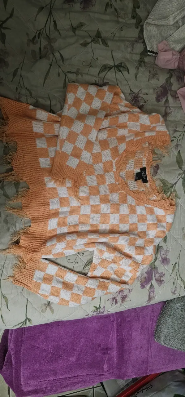 Suéter a cuadros naranja y blanco con flecos