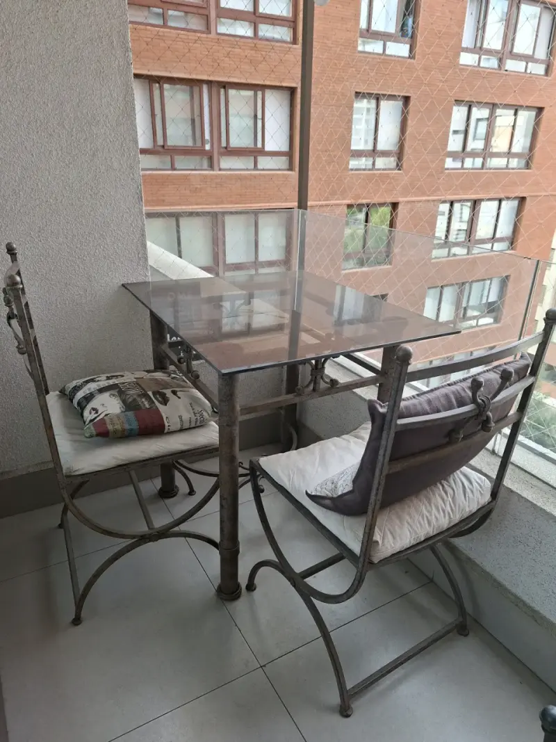 Juego de comedor de terraza con mesa de vidrio y sillas de hierro