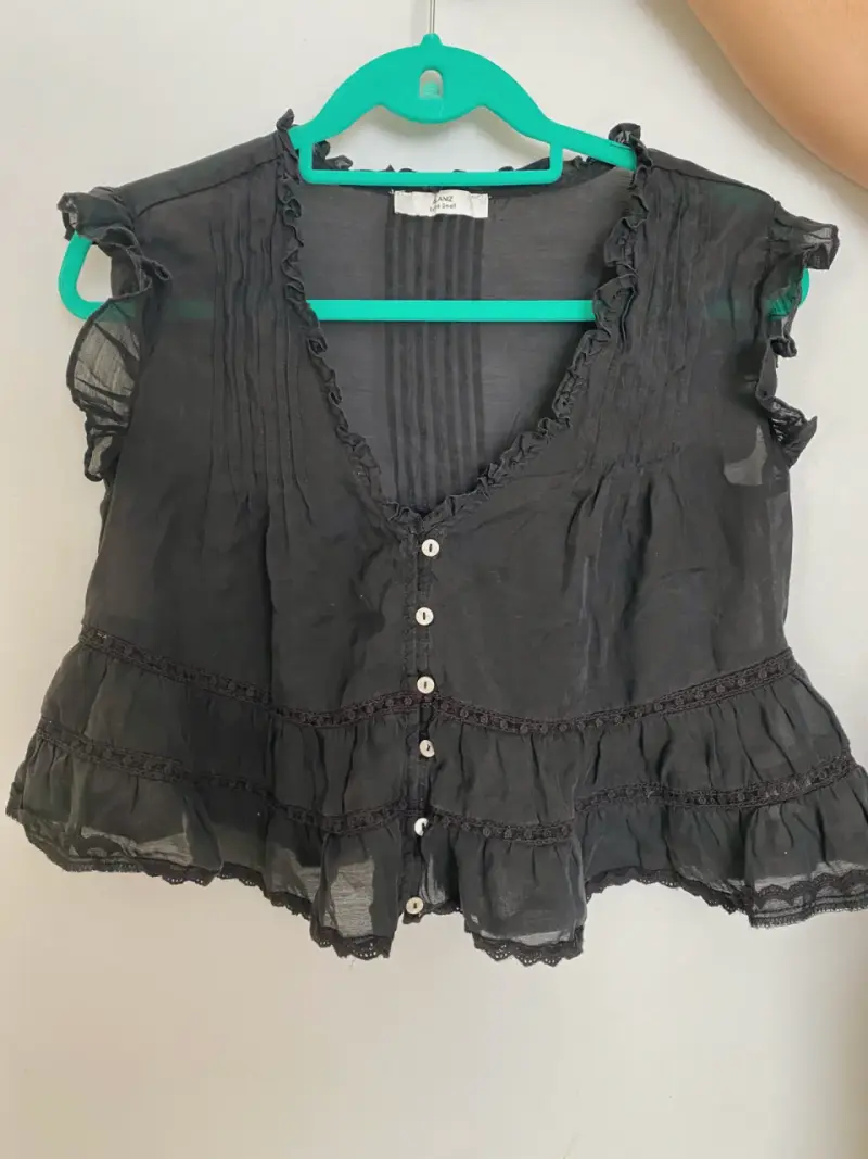 Blusa negra con volantes y botones