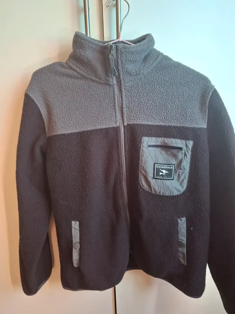 Chaqueta polar negra con bolsillo frontal