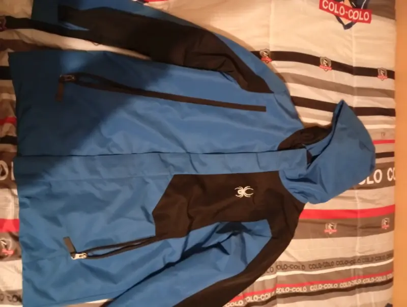 Chaqueta impermeable azul y negra con capucha
