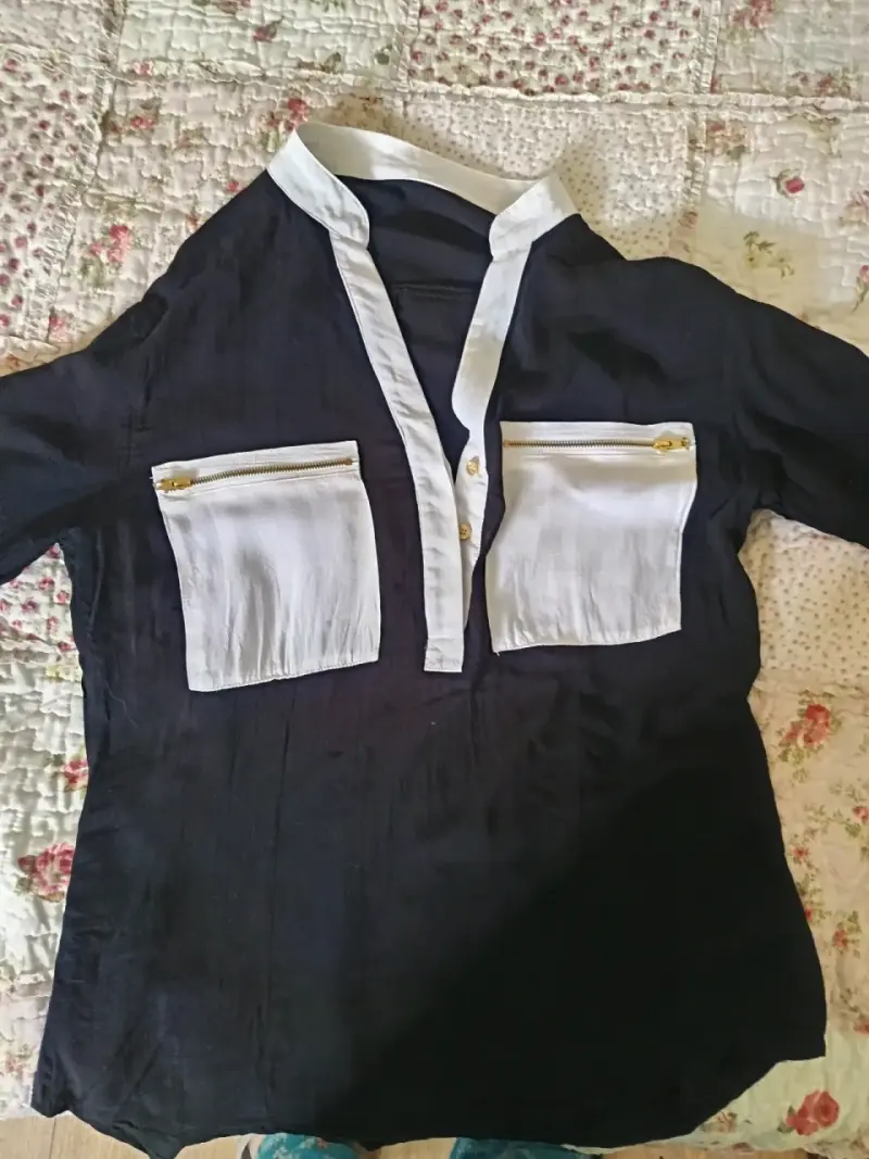 Blusa negra con detalles blancos y bolsillos