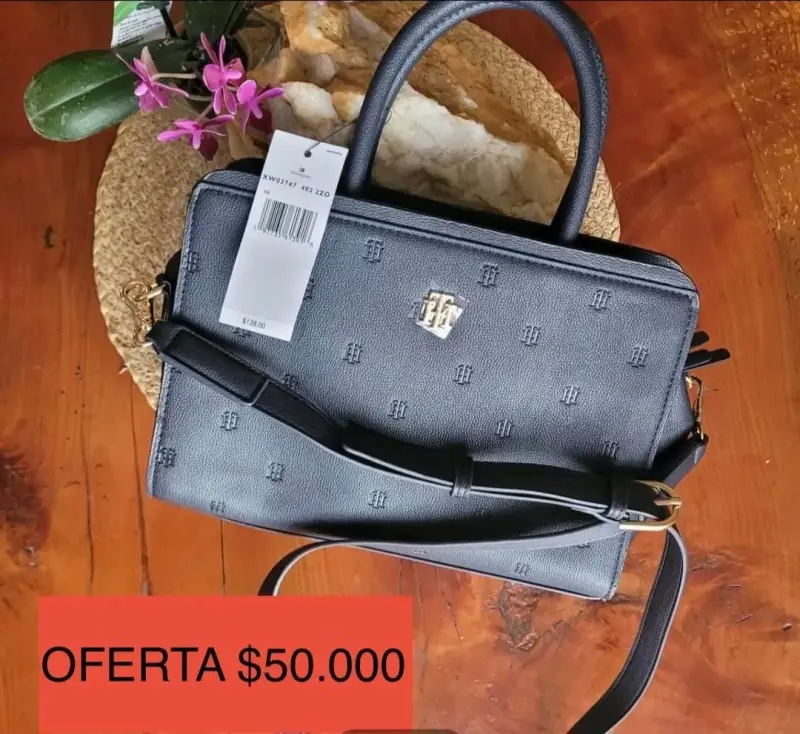 Cartera de mano azul marino con logo dorado