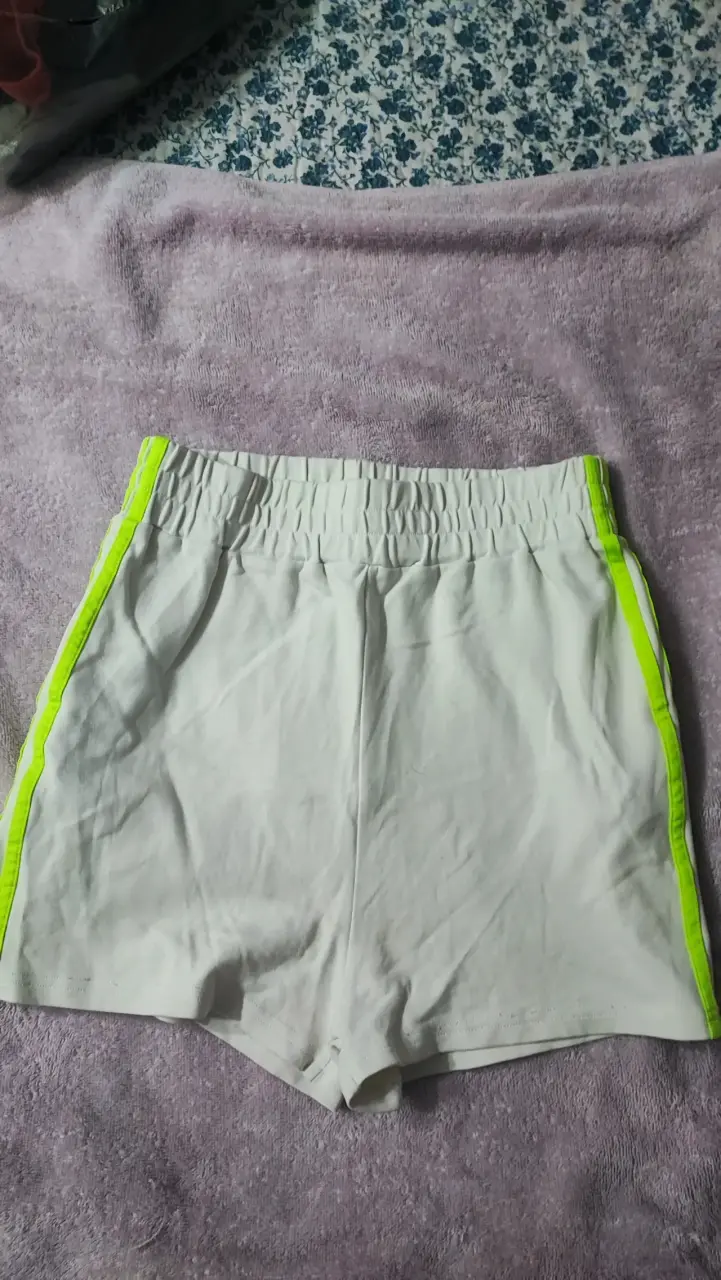 Shorts deportivos blancos con franjas verdes