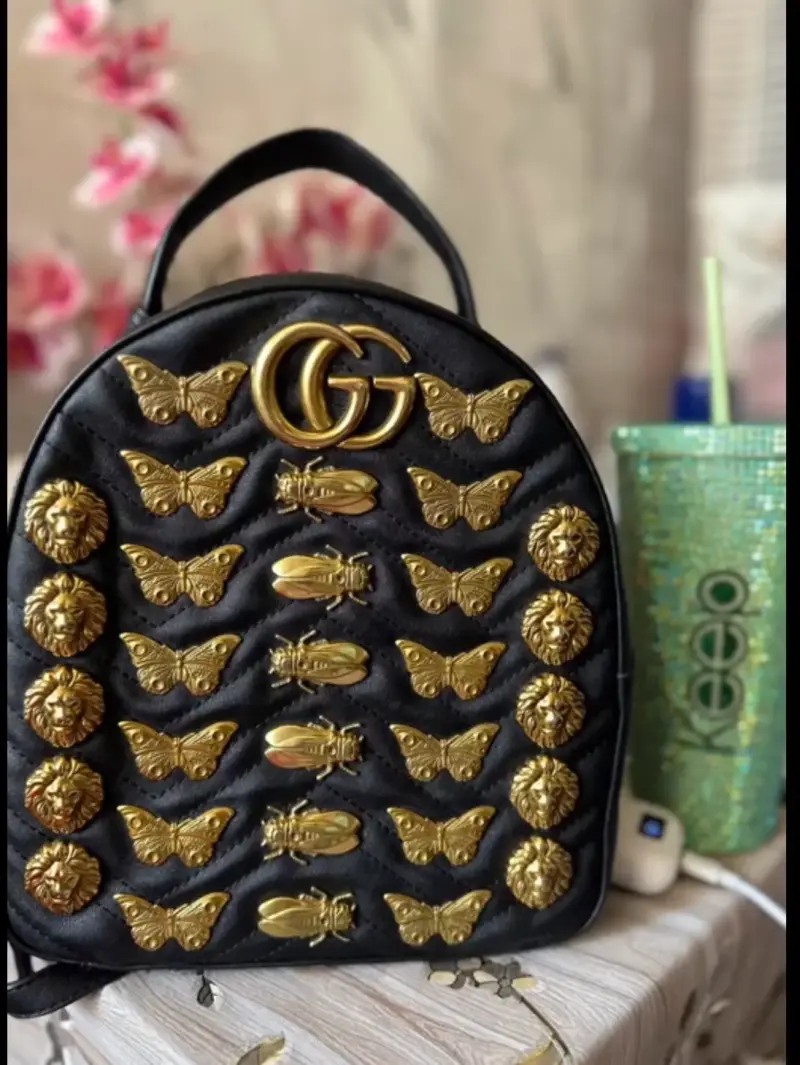 Mochila negra con adornos dorados GG
