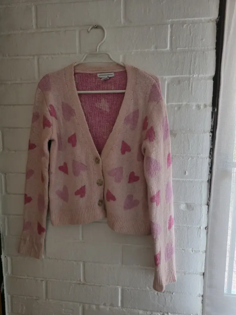 Cárdigan de punto rosado con corazones