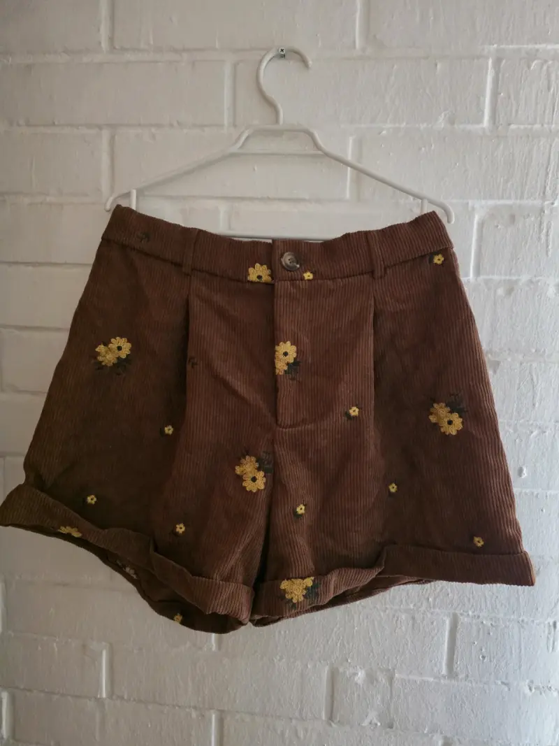Shorts de cotelé marrón con flores bordadas