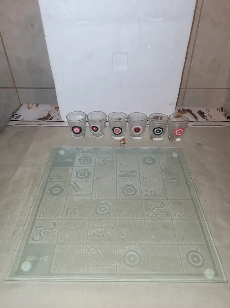 Juego de mesa con vasos de shot y dado