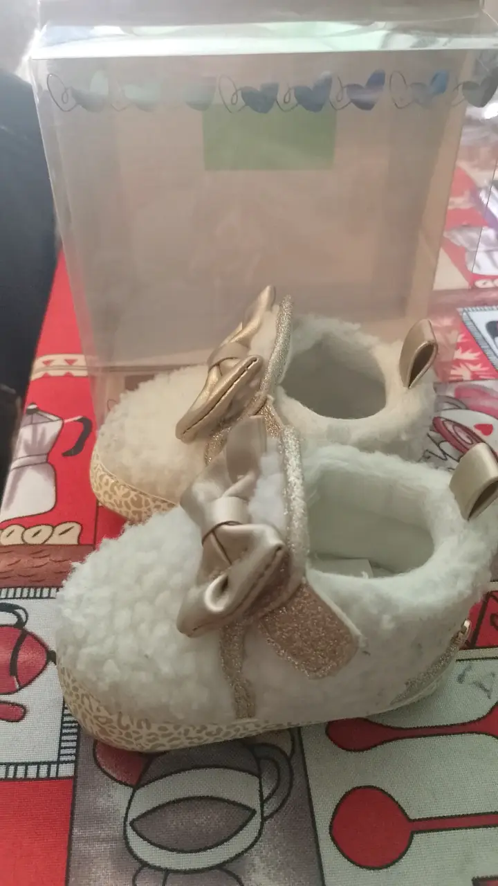 Zapatos de bebé con lazo dorado y peluche