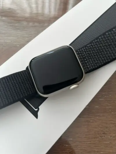 Apple Watch con correa negra y cargador - miniatura 1