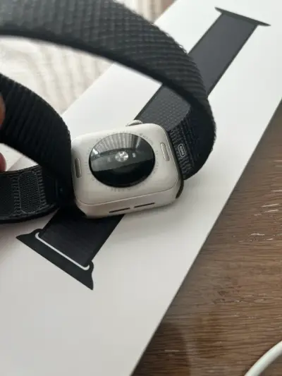 Apple Watch con correa negra y cargador - miniatura 2