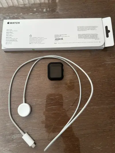 Apple Watch con correa negra y cargador - miniatura 3