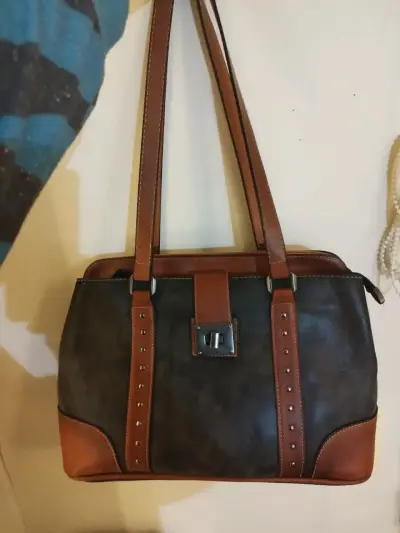Cartera de cuero marrón y negro con detalles metálicos - miniatura 1