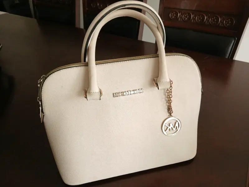 Bolso de mano beige.