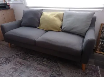 Sofá gris de tela con cojines - miniatura 1