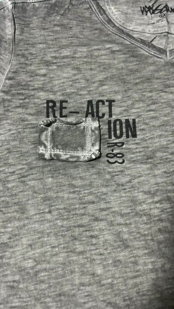 Polera gris con bolsillo y estampado React - 2