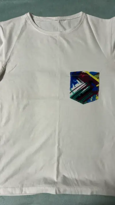 Polera blanca con bolsillo estampado colorido - miniatura 1